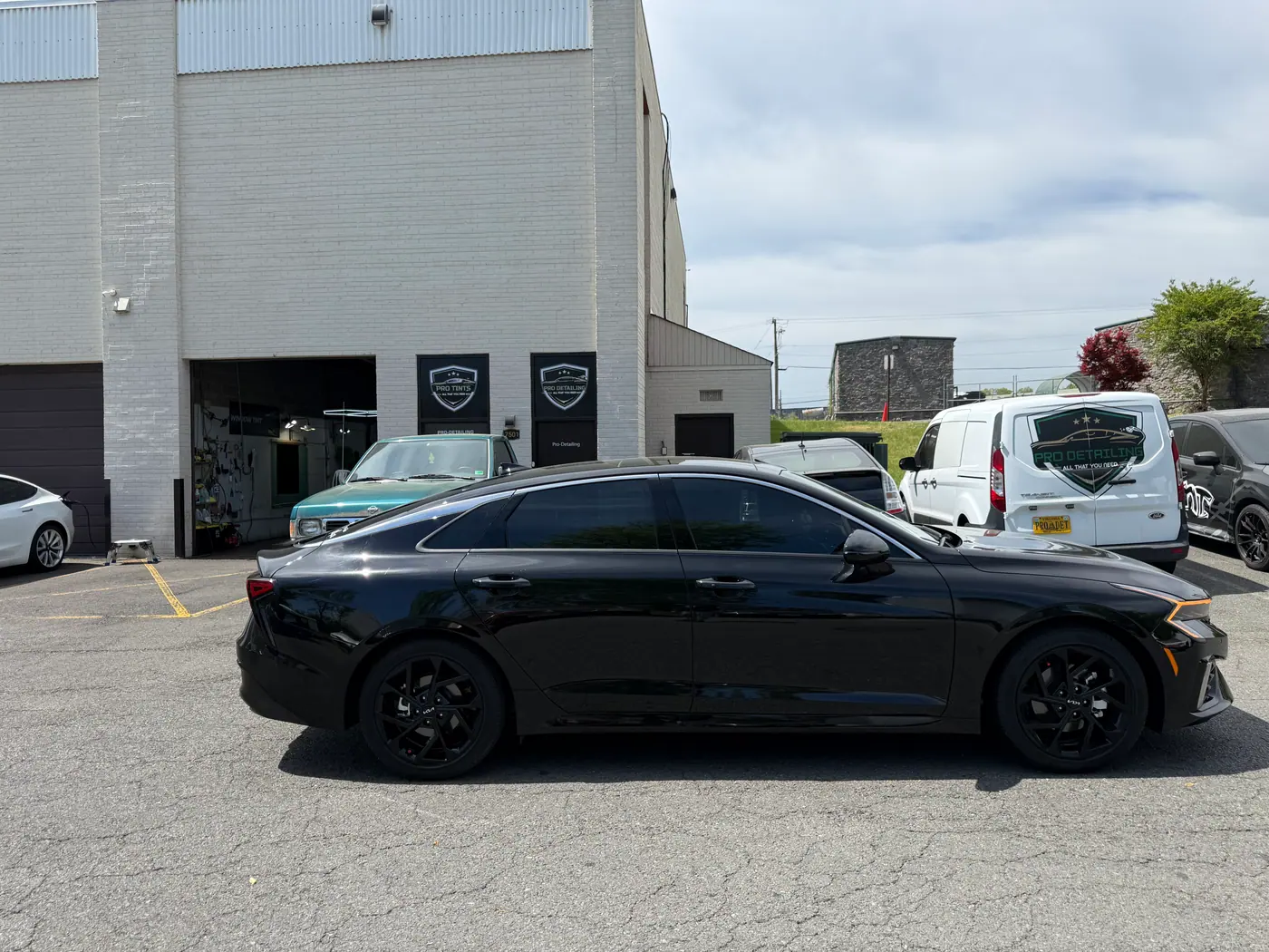 Black sedan with tinted windows, photographed side-on.