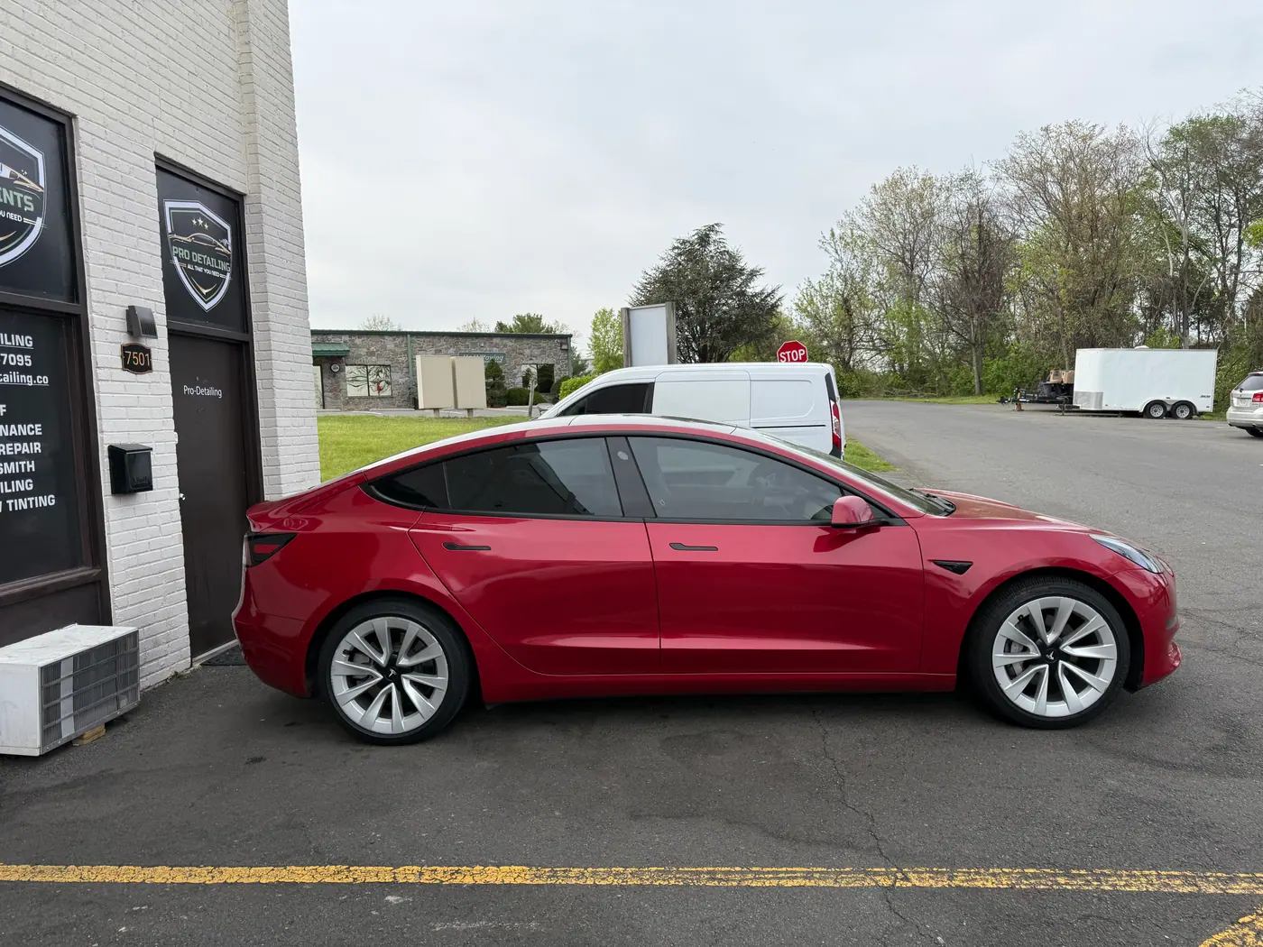 Red sedan with tinted windows, photographed side-on.