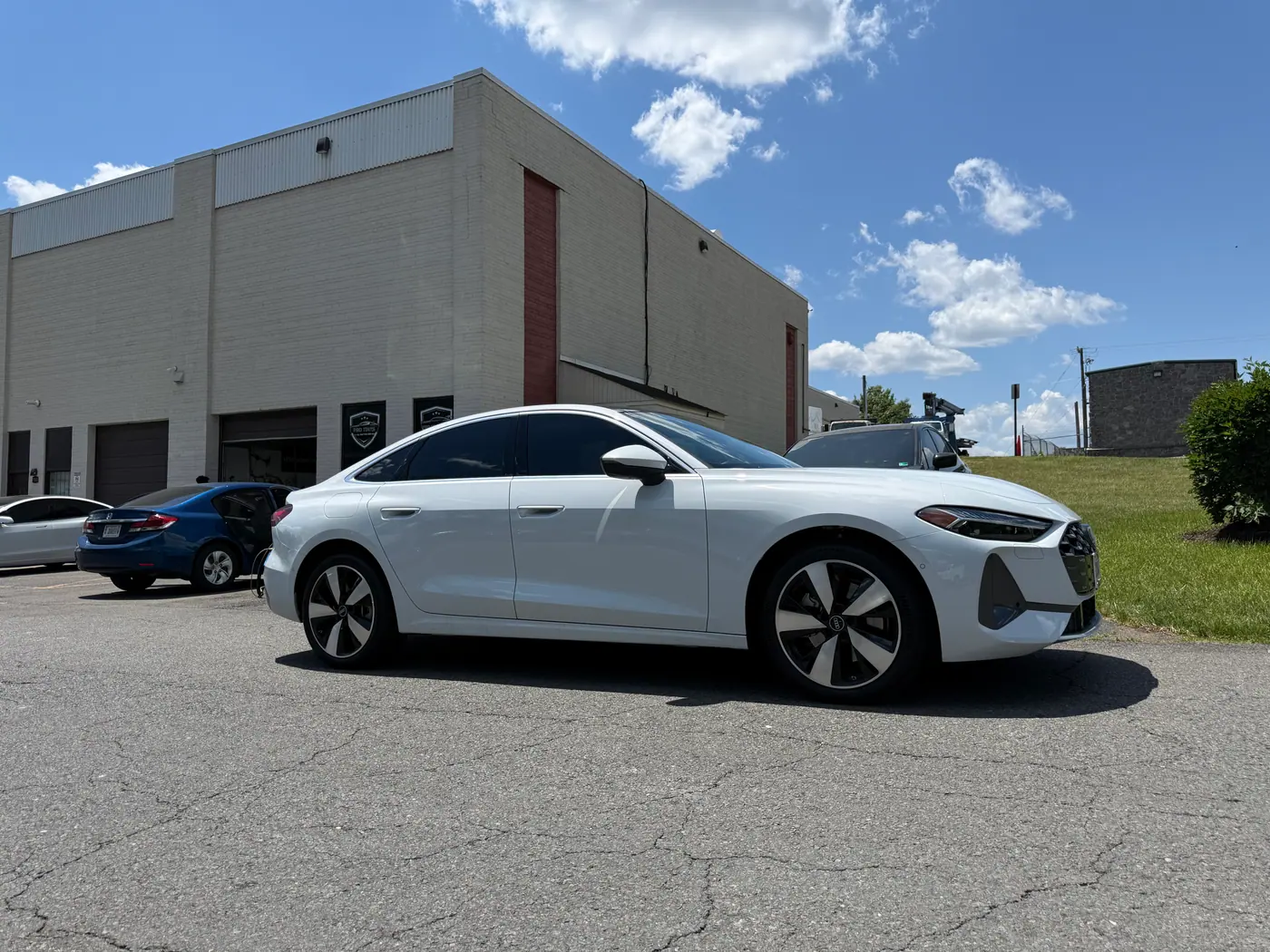 White sedan with tinted windows, photographed side-on.