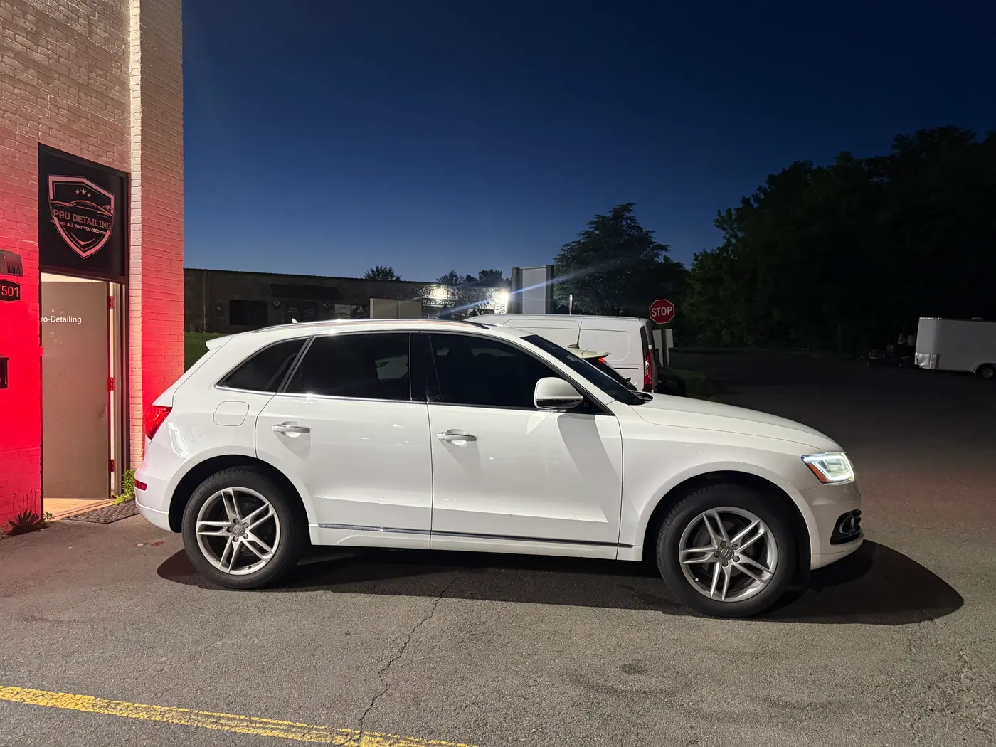 White SUV with tinted windows, photographed side-on at dusk.