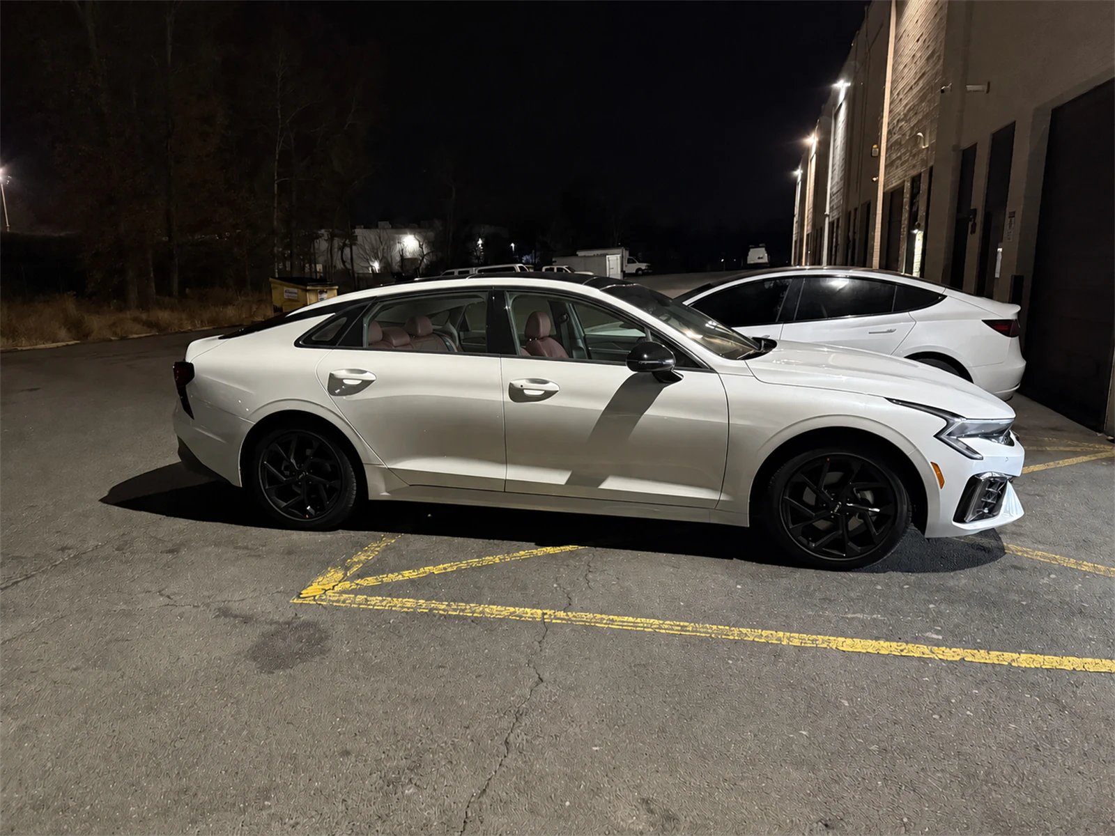 Interactive comparison of clear and tinted side glass on the same white sedan at night