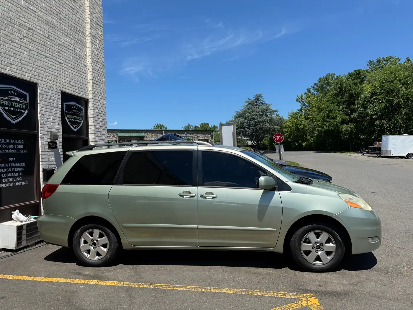 Green minivan with tinted windows, photographed side-on: window tint by PRO Detailing, serving Bristow, VA drivers.
